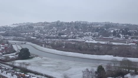 Tiro-De-Dron-De-Seguimiento-Lateral-De-Exeter-Nevado-Sobre-El-Río-Exe-Crop