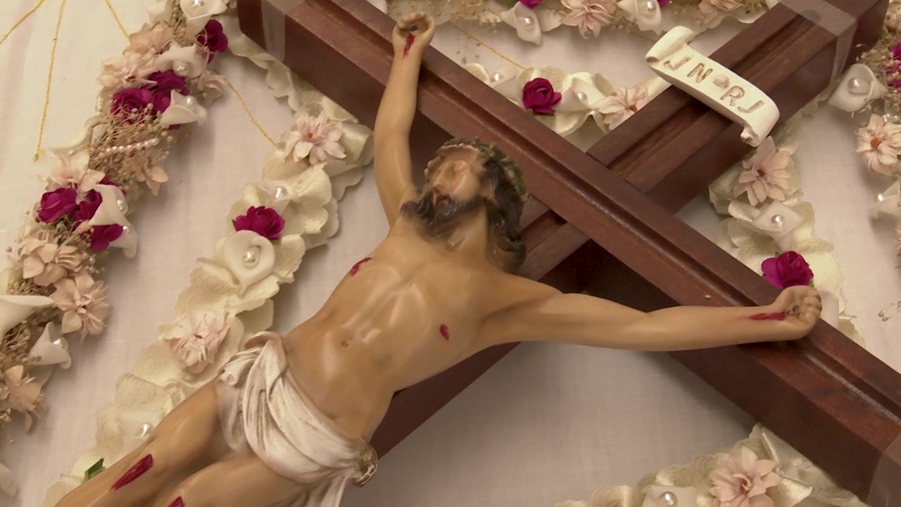Statua di Gesù crocifisso adornata di fiori
