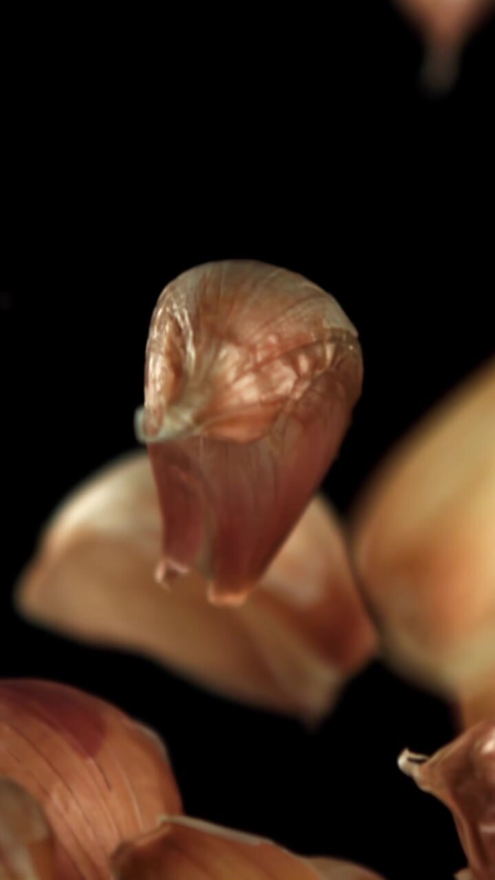 Fresh Garlic Cloves Falling in Slow Motion on Black Background