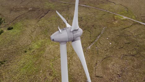 dynamic aerial shot of the moorland landscape around a wind turbine