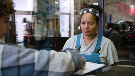 cliente pagando al mecanico