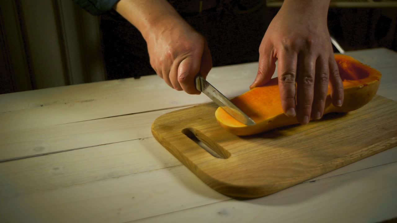 cortando una sabrosa rebanada de calabaza. manos masculinas preparando comida calabaza para cocinar