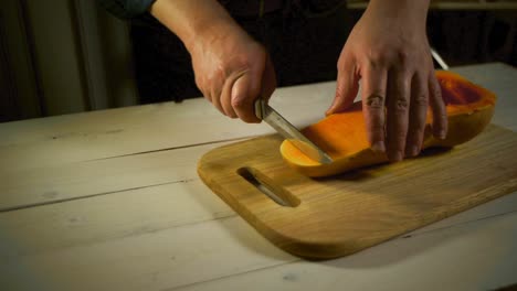 cutting tasty pumpkin slice. male hands preparing food pumpkin for cooking