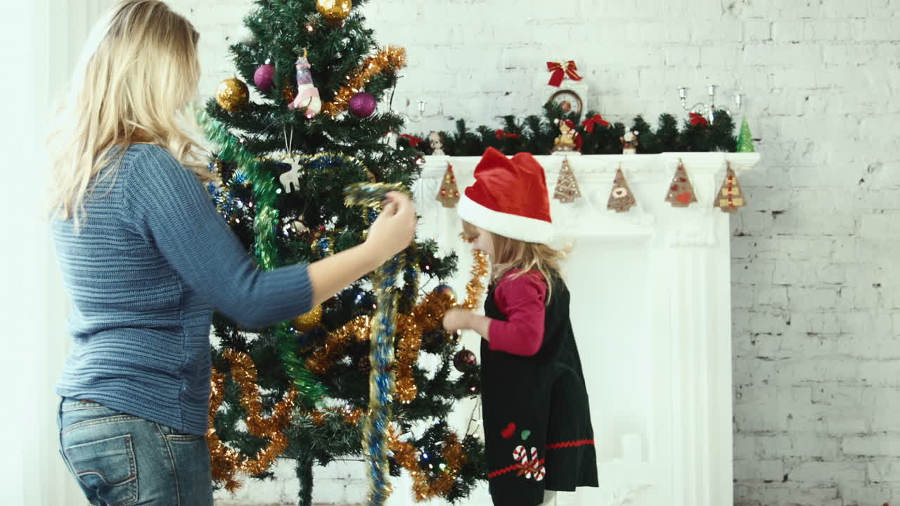 madre e hija decorando el árbol de Navidad