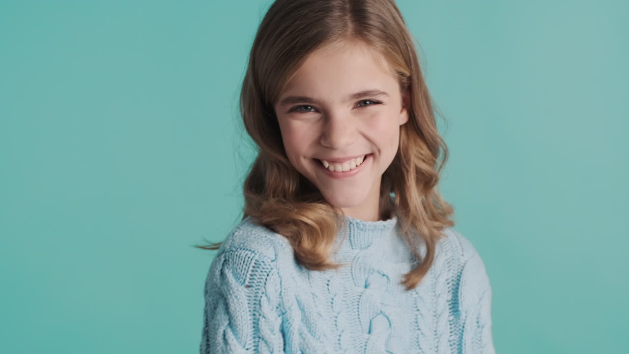 подростковая белая девушка делает смешные лица перед камерой.