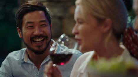 amigos celebrando en una fiesta de cena haciendo brindis bebiendo vino disfrutando de una feliz reunión charlando compartiendo comida divirtiéndose por la noche sentados a la mesa al aire libre 4k