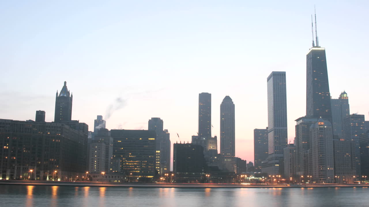las luces se iluminan a medida que el cielo se oscurece en el centro de chicago