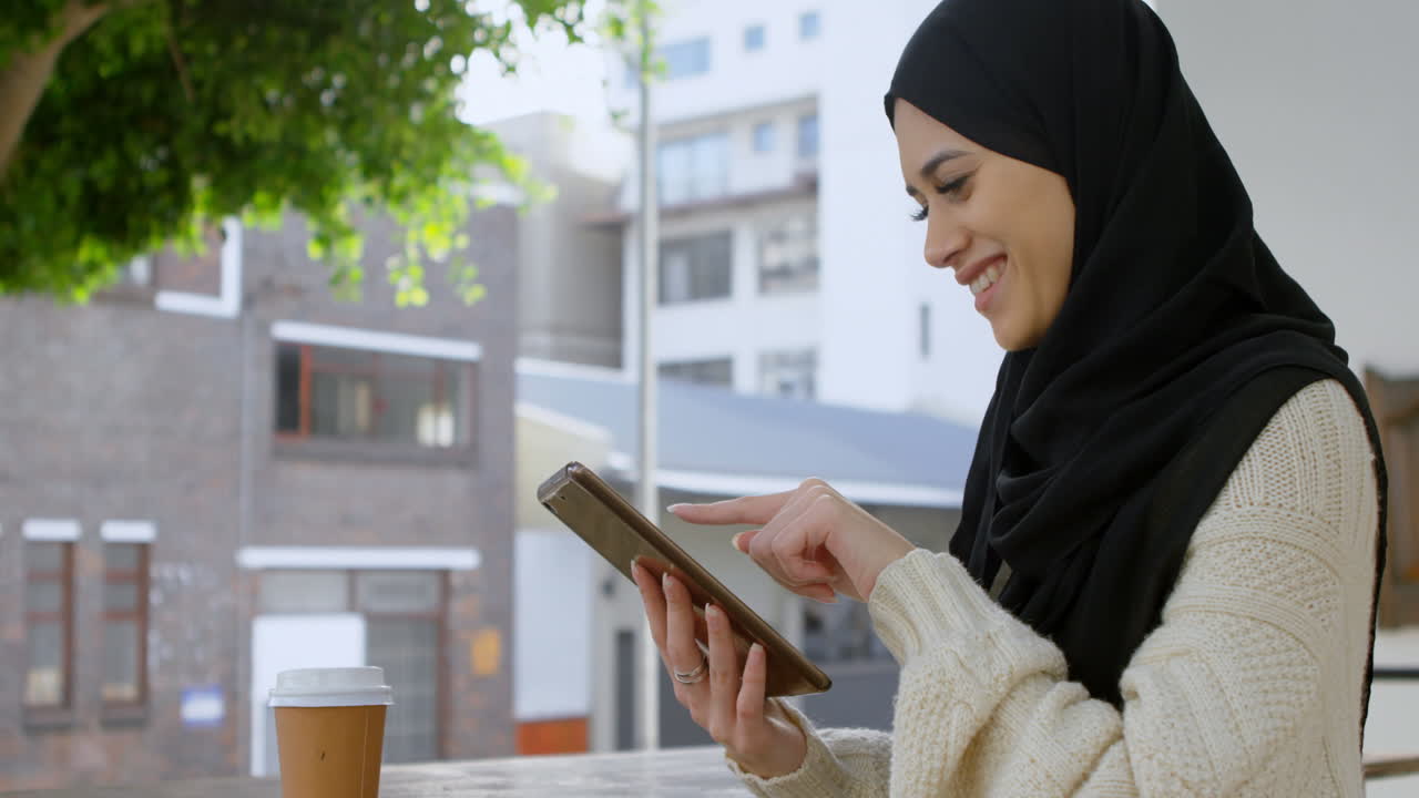 una hermosa mujer con hijab usando una tableta 4k