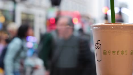 crowded street scene with a beverage in focus