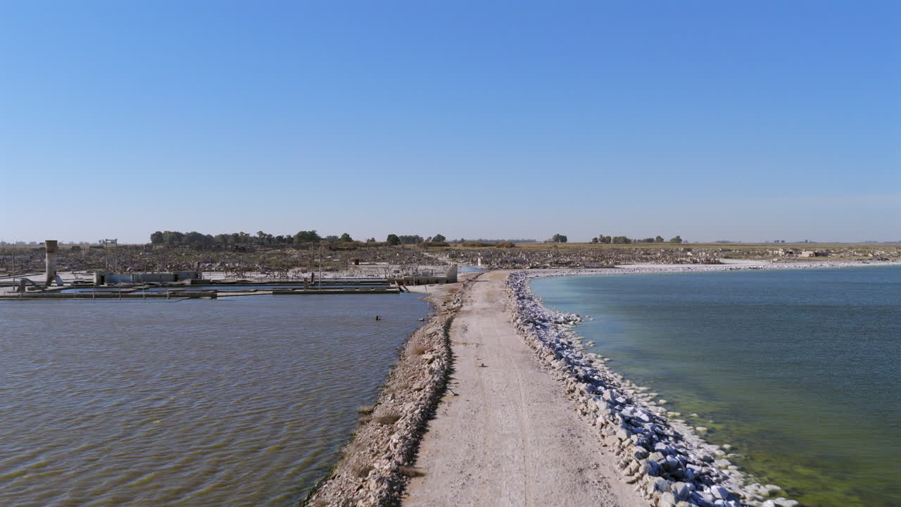 Drone flying over the narrow road surrounded by the waters of Epecuén Lake in Buenos Aires Province, Argentina