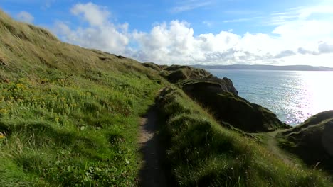 walking along a coastal path over looking the ocean on a sunny day