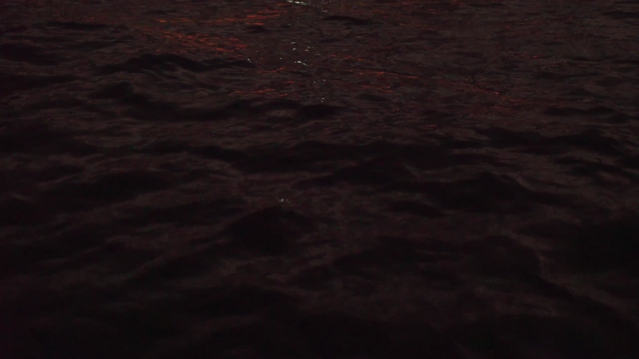 olas oscuras del océano meciéndose con el reflejo de la puesta de sol