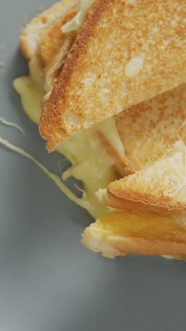 video de la vista aérea de un sándwich de pan blanco con queso recién preparado en un plato blanco