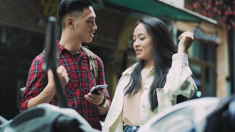 handheld view of vietnamese couple with mobile phone in town