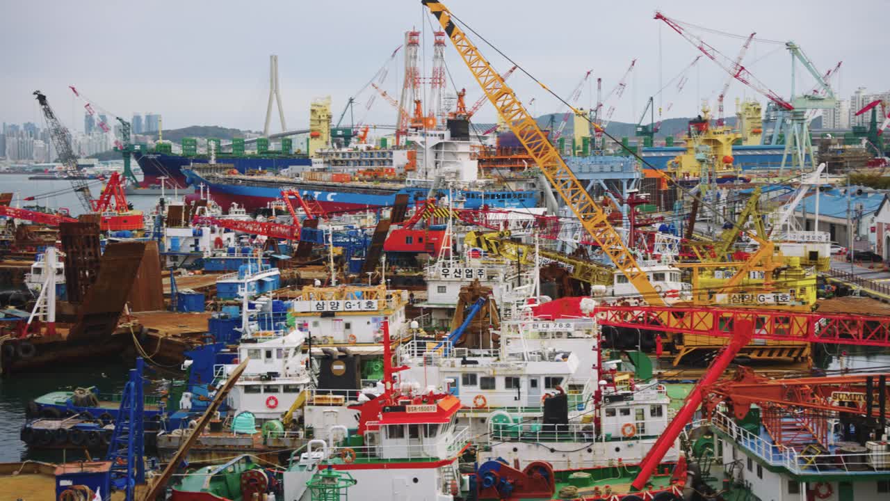 흐린 날 에 한국 의 부산 항구 에 있는 크레인 과 어선 들