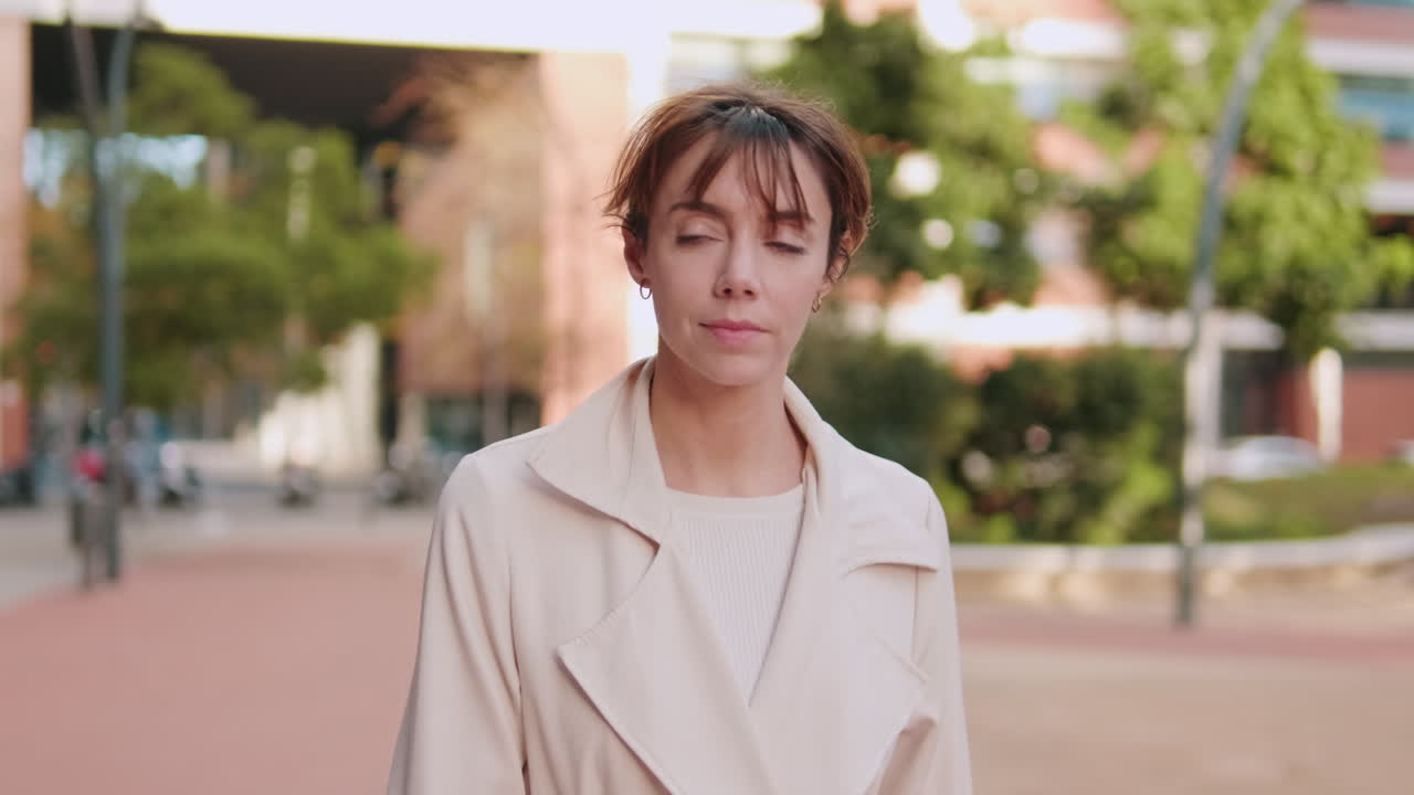 Thoughtful Woman Standing Outdoors with Eyes Closed in Urban Setting
