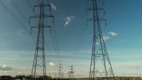 Electricity-Pylons-Against-Blue-Sky-At-Eling-Great-Marsh,-Southampton,-England,-UK---drone-shot