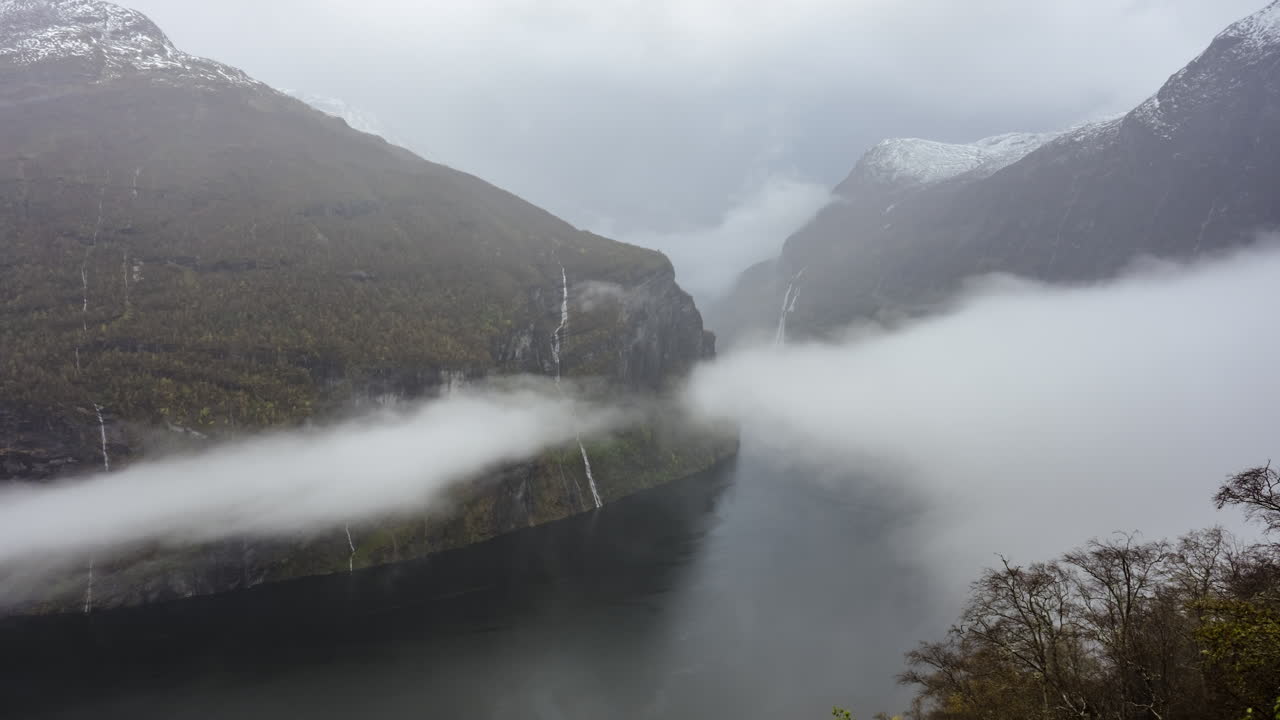 노르웨이의 ornesvingen 관점에서 폭포와 산 사이의 geirangerfjord 위로 이동하는 구름