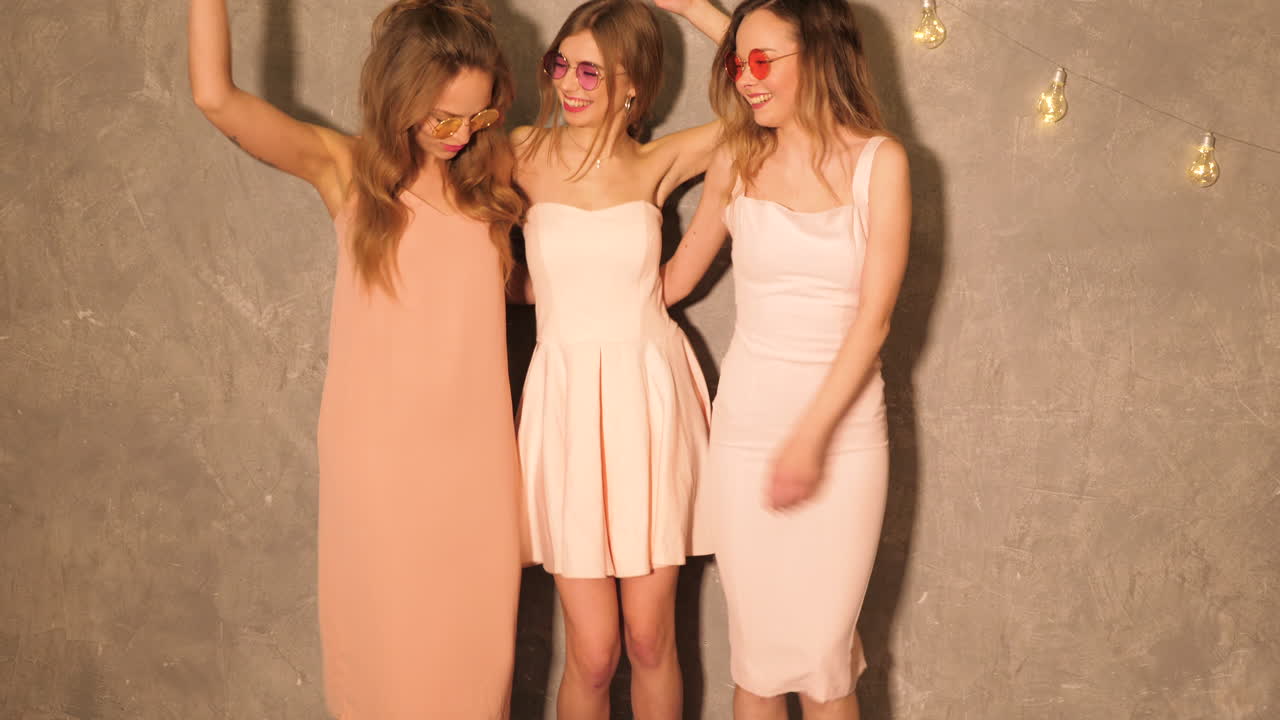 세 명의 친구들이 드레스를 입고 춤을 춘다.