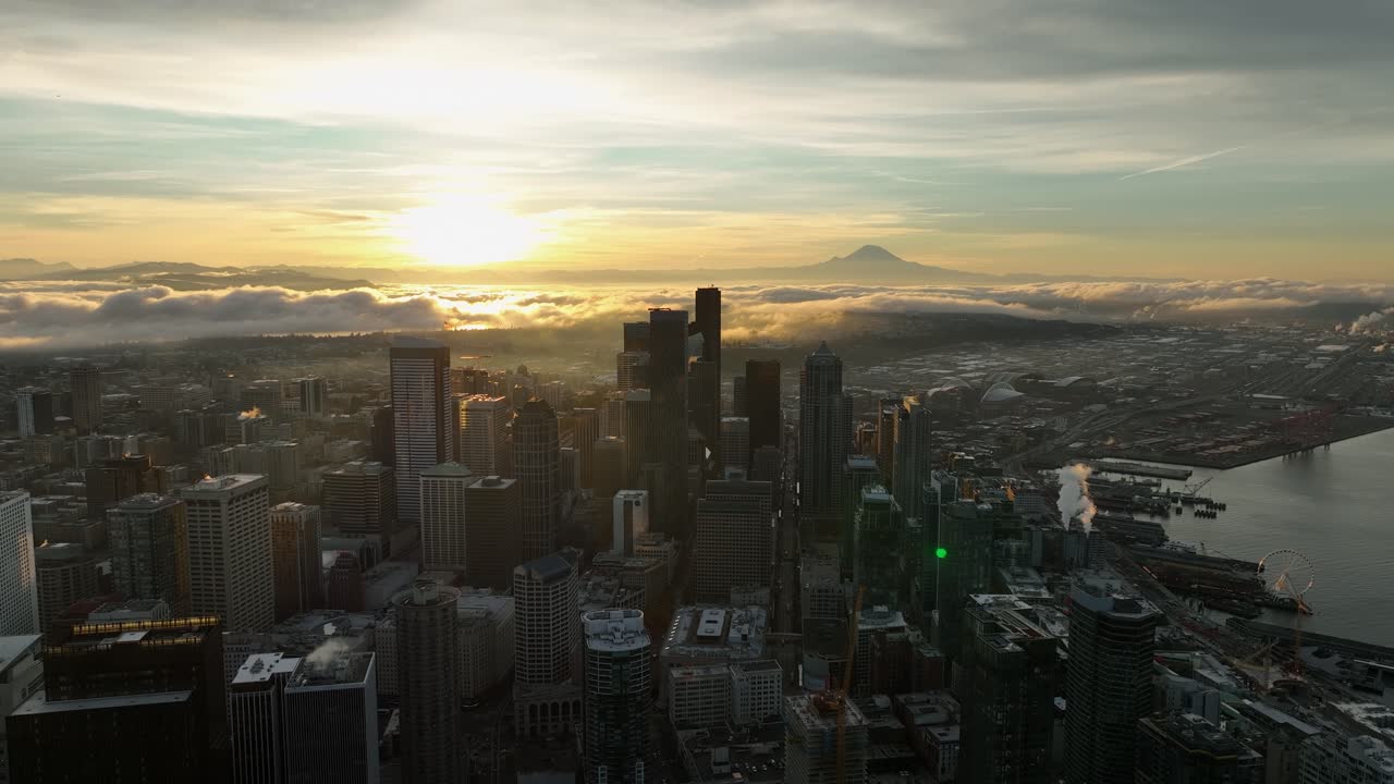 Cena tranquila de um nascer do sol nublado iluminando o horizonte de Seattle, vista aérea.