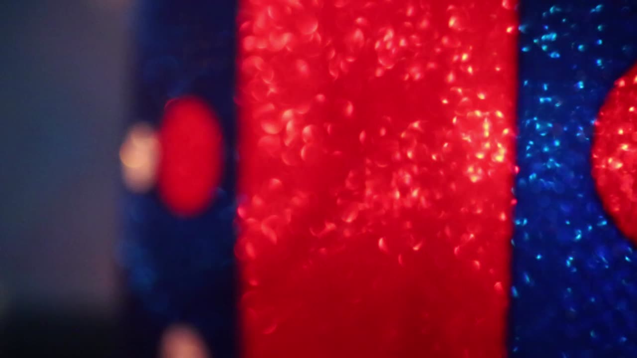 移动远离波尔卡点红 - 蓝色照亮的圣诞礼物, 脱离焦点, 利用灯光进行有趣的效果