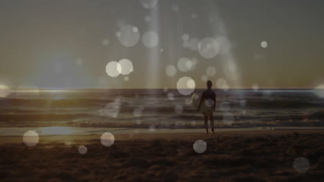 senior man holding surfboard at beach during sunset, showcasing travel marketing with bokeh flares