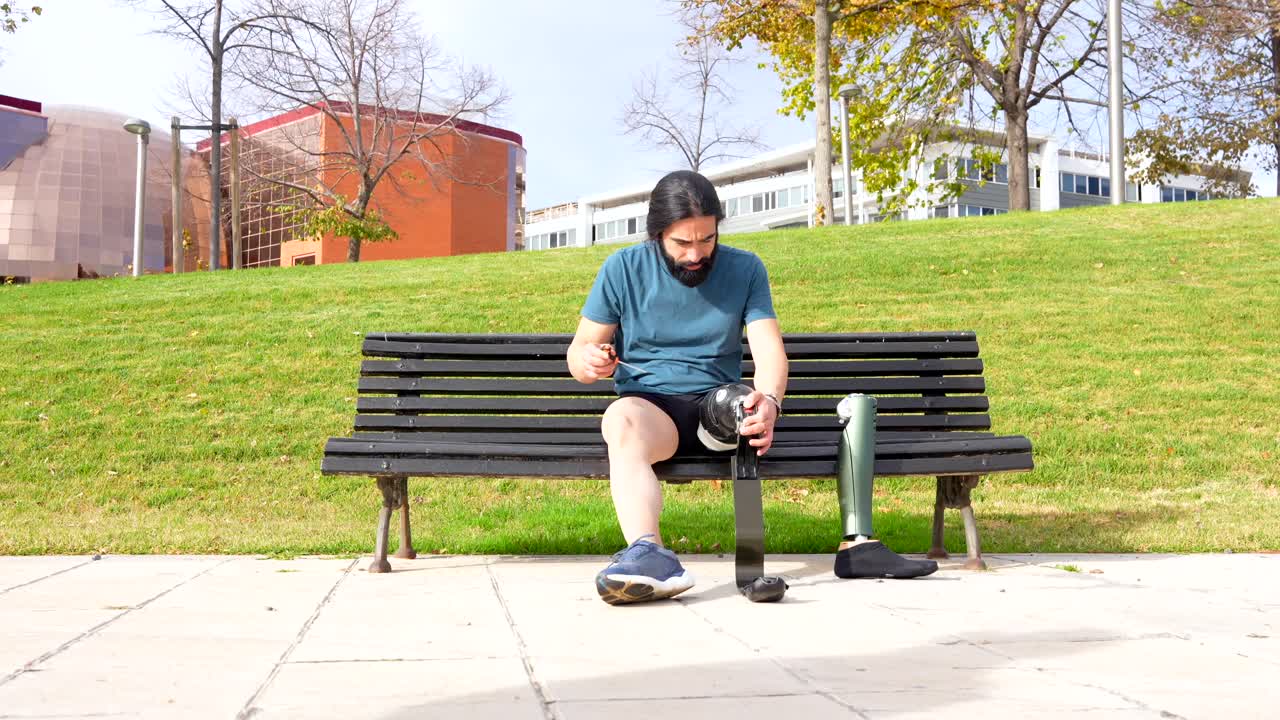 Man with Prosthetic Leg Sitting on Bench in Park