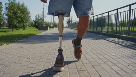 person with prosthetic leg walking in park