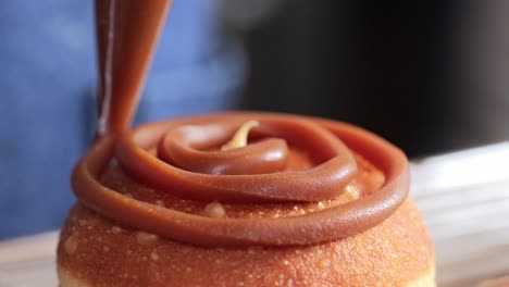 caramel donut being decorated  side view filling