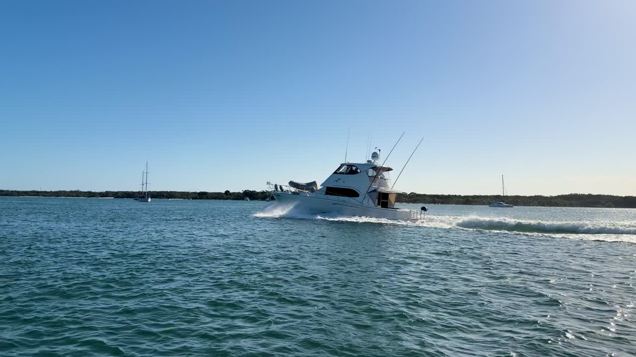 Un lussuoso yacht bianco naviga nelle calme acque dell'oceano sotto un cielo azzurro.