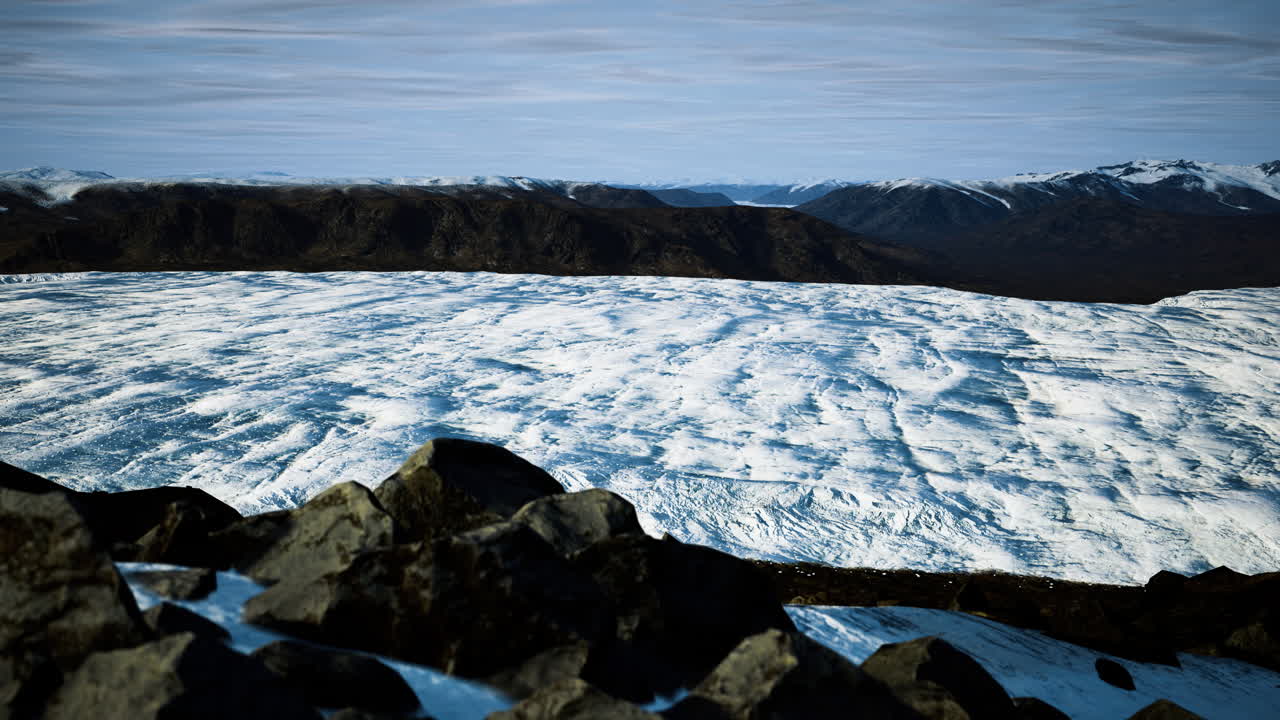 Vast ice field stretches across mountains in a remote icy landscape