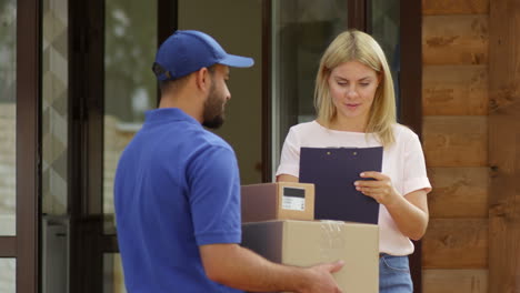 delivery man gives a package to a blonde woman on the street