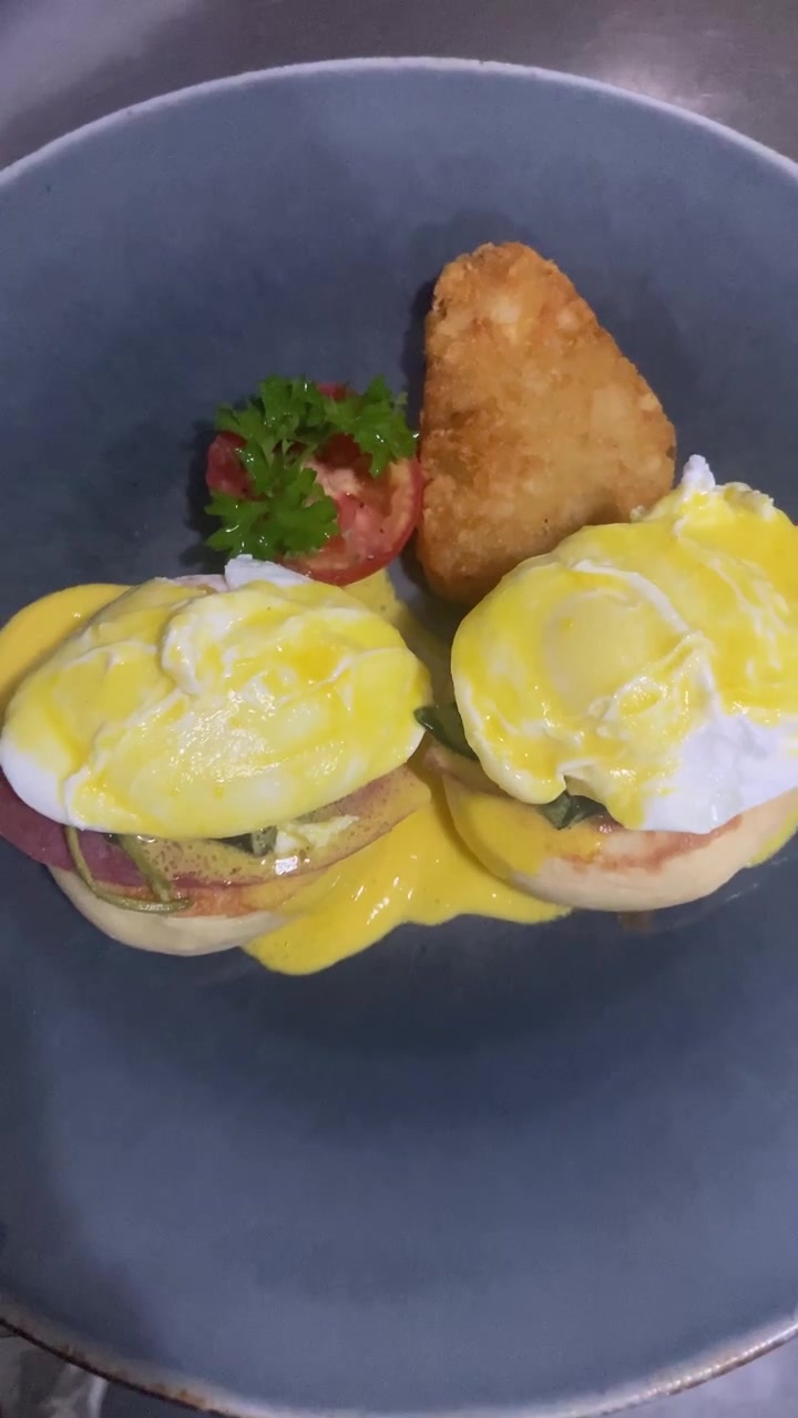 Deliziose Uova alla Benedict servite con hash brown su un piatto.