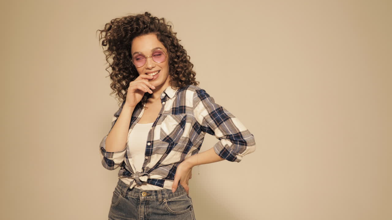 mujer elegante con el cabello rizado en una camisa a cuadros