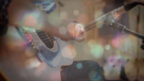 Glowing-spots-of-lights-against-man-playing-guitar