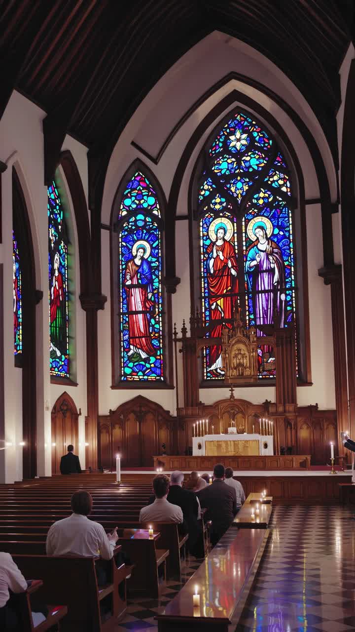 Il video riprende un sereno interno di una chiesa con vetrate artistiche da un angolo basso