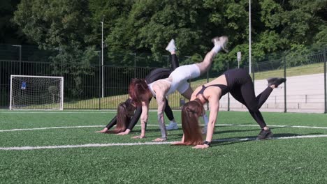 three athletes perform a training routine on a sunny football field showcasing teamwork and strength three athletes perform a training routine on a sunny football field showcasing teamwork and strength