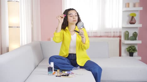 Young-woman-is-applying-mascara-to-her-eyes.