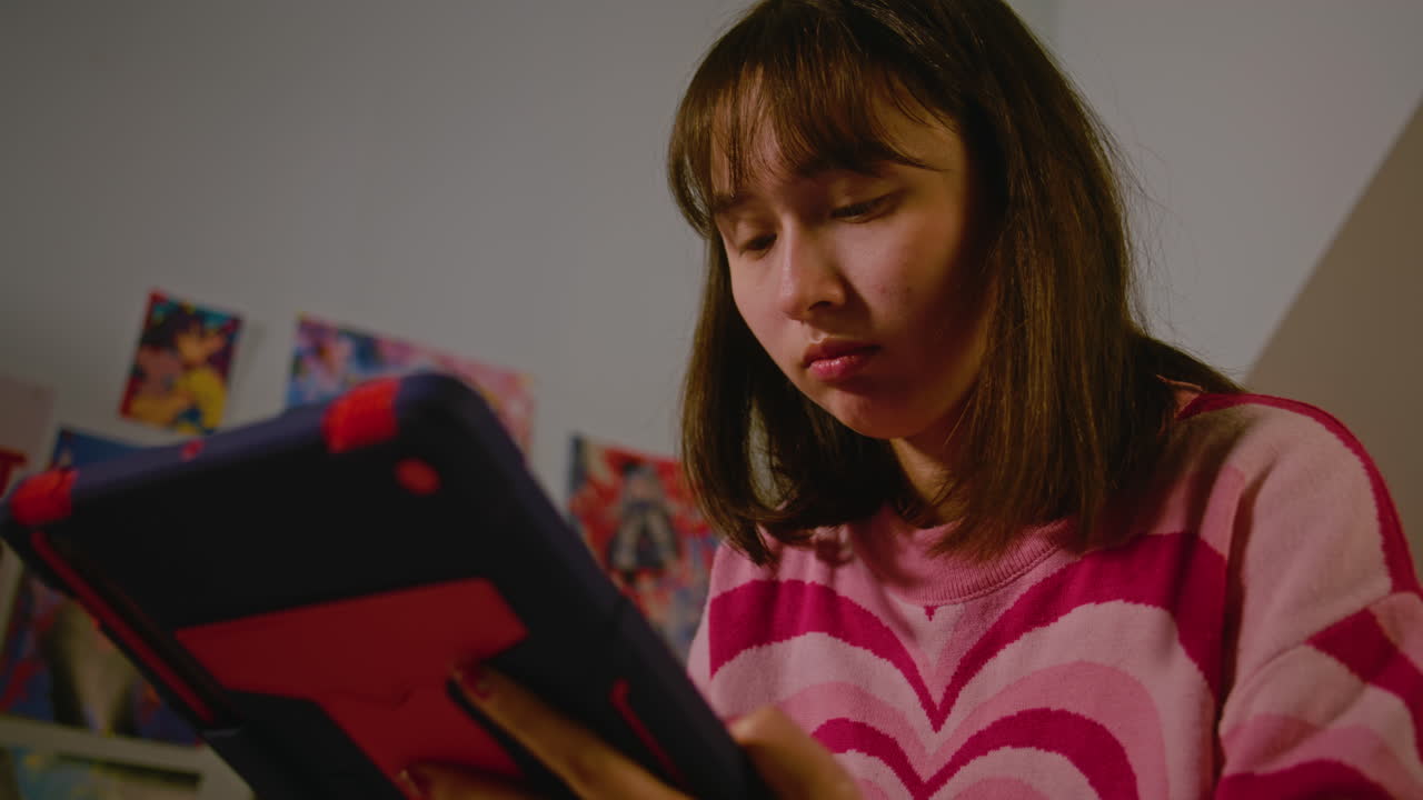 Teenage Girl Using Tablet in Bedroom