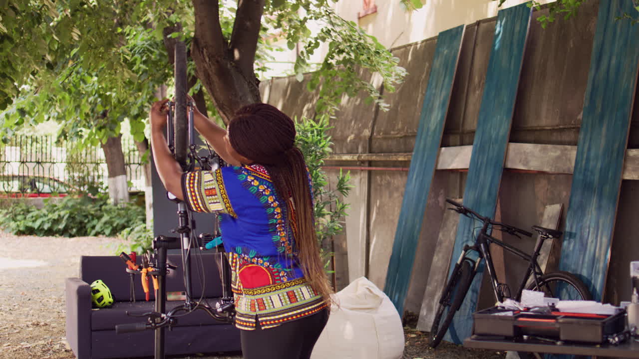 마당 에서 자전거 바 ⁇  를 풀고 있는 여자