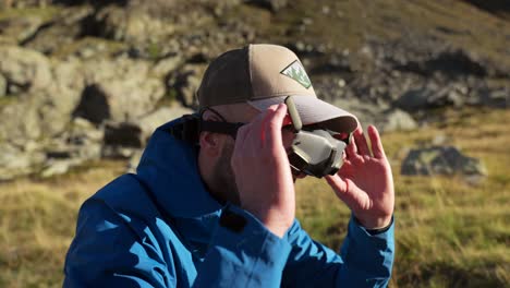 drone pilot prepares for flight by wearing fpv drone goggles