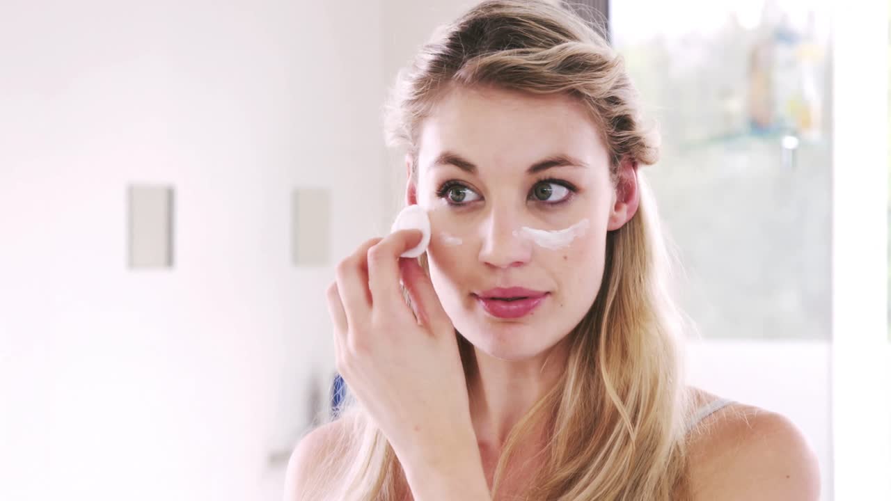 bonitas rubias aplicando crema en su cara