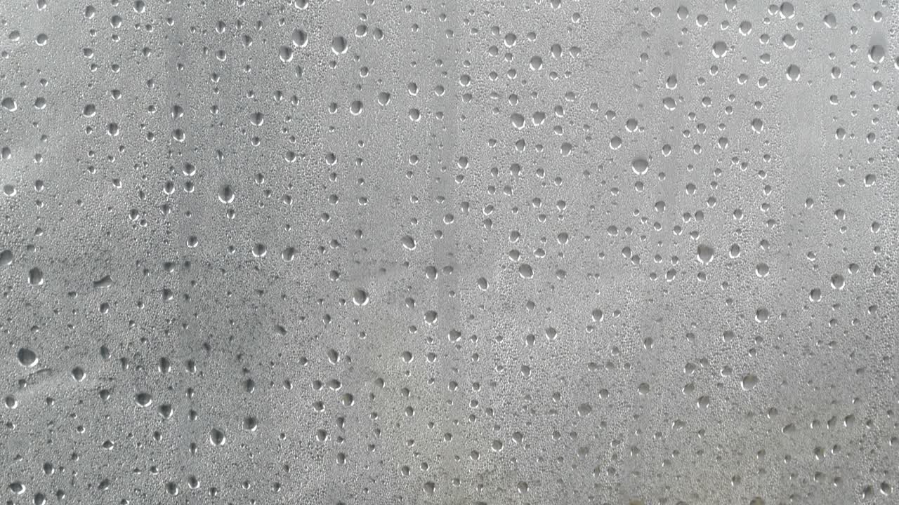 muchas gotas de agua en la condensación de la superficie gris oscuro.