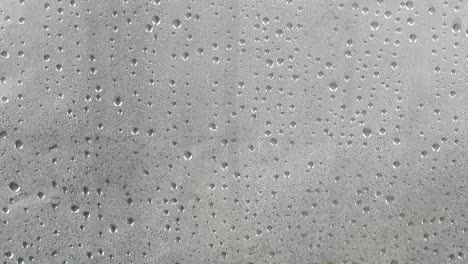 many water drops on dark gray surface condensation.