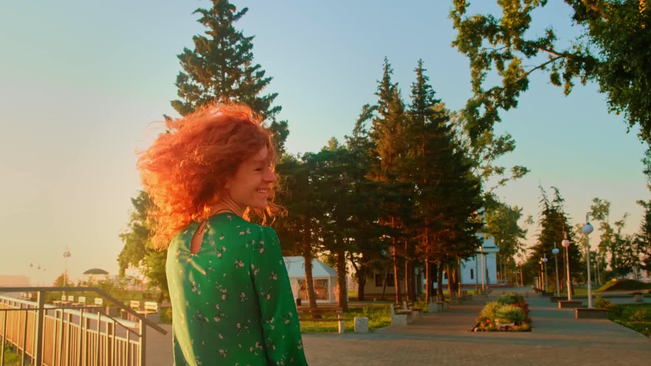 A Woman with Fiery Hair Ascends the Stairs in a Sunshine-Drenched Landscape, Carrying a Bright Orange Bag While Embracing the Lush Surroundings