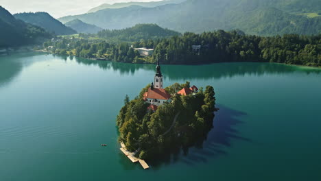 drone orbit around bled island slovenia, flat lake, long shadows