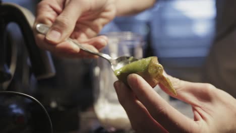 preparing a fruit smoothie mixture with a kiwi fruit - close up shot