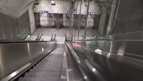 Pov-De-Una-Persona-Que-Viaja-En-Una-Escalera-Mecánica-Y-Baja-Dentro-De-La-Estación-De-Metro-De-Nationaltheatret-En-Oslo,-Noruega-Durante-La-Pandemia-De-Covid-19