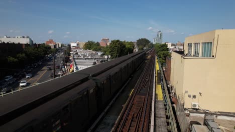 an aerial view of elevated train tracks with a historic train travelling away from the camera on a sunny day