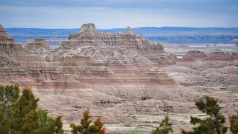 a towering peak overlooking badlands national park, united states, with some foliage in the lower foreground